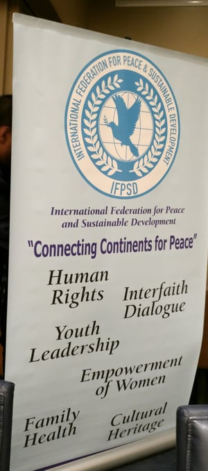 国連認証機関である平和と持続的開発に関する国際機関（IPSD）のバナーには人権、宗教観対話、若年層のリーダーシップ、女性の社会参加、家族の健康、文化遺産
