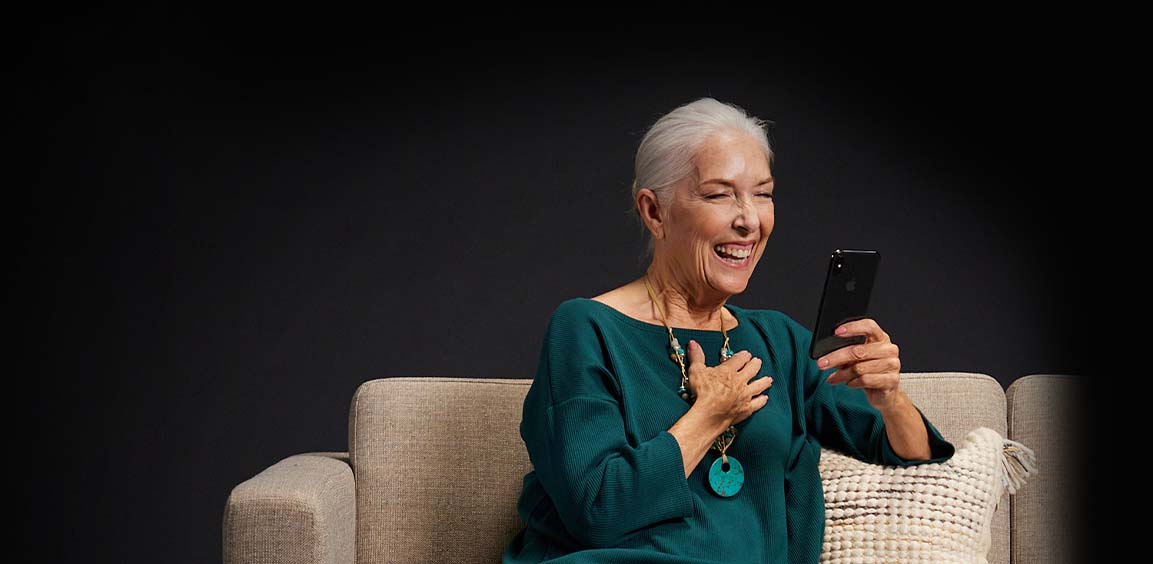 woman-looking-at-her-phone-and-laughing